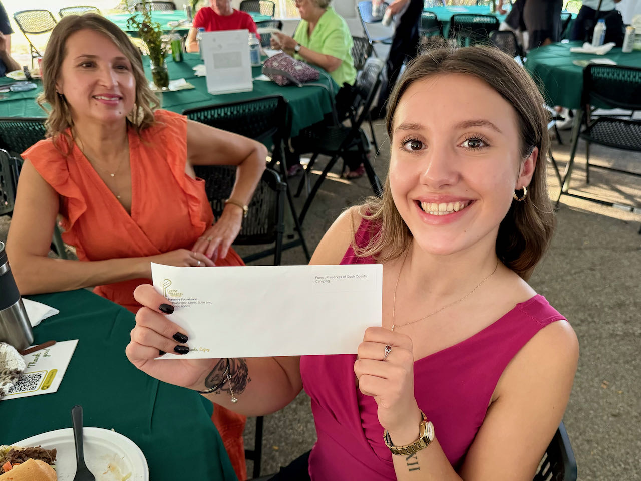 Conservation Corps speaker Arianna Telles was thrilled to receive the voucher for camping at the Forest Preserves of Cook County from donor Allison Downing.