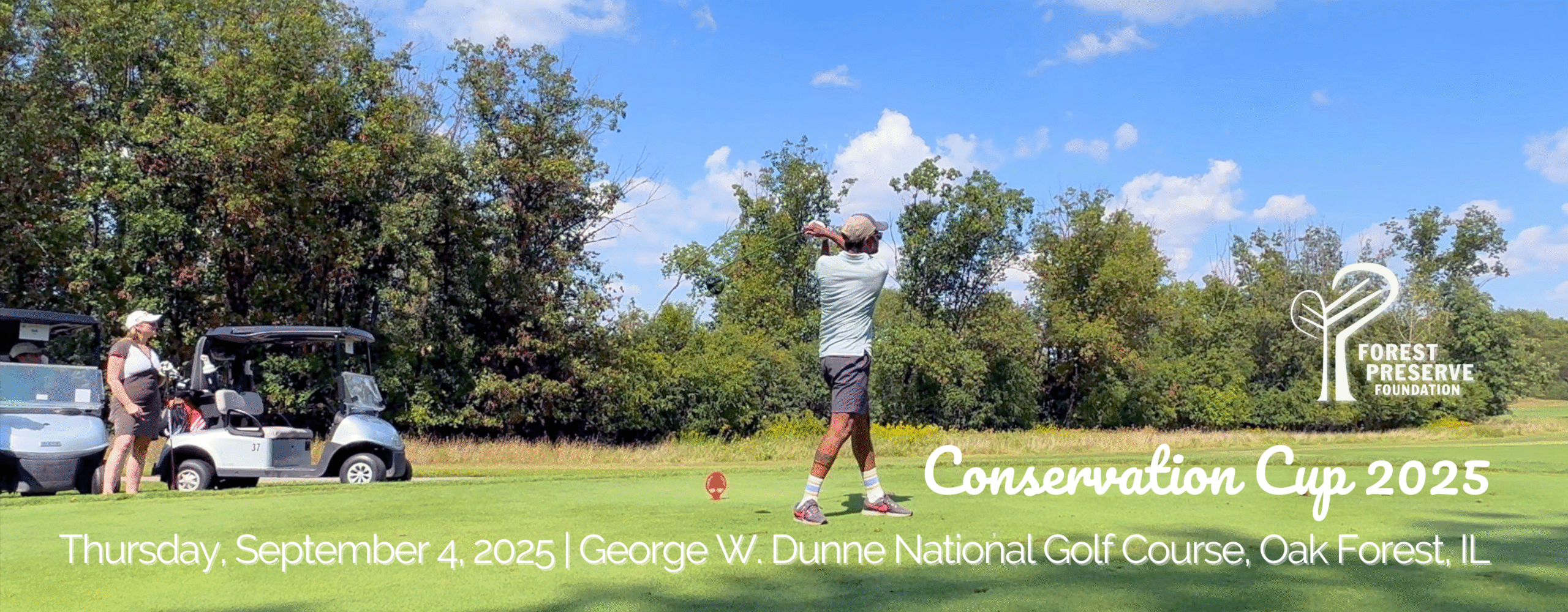 A golfer hitting a ball against green trees and blue sky